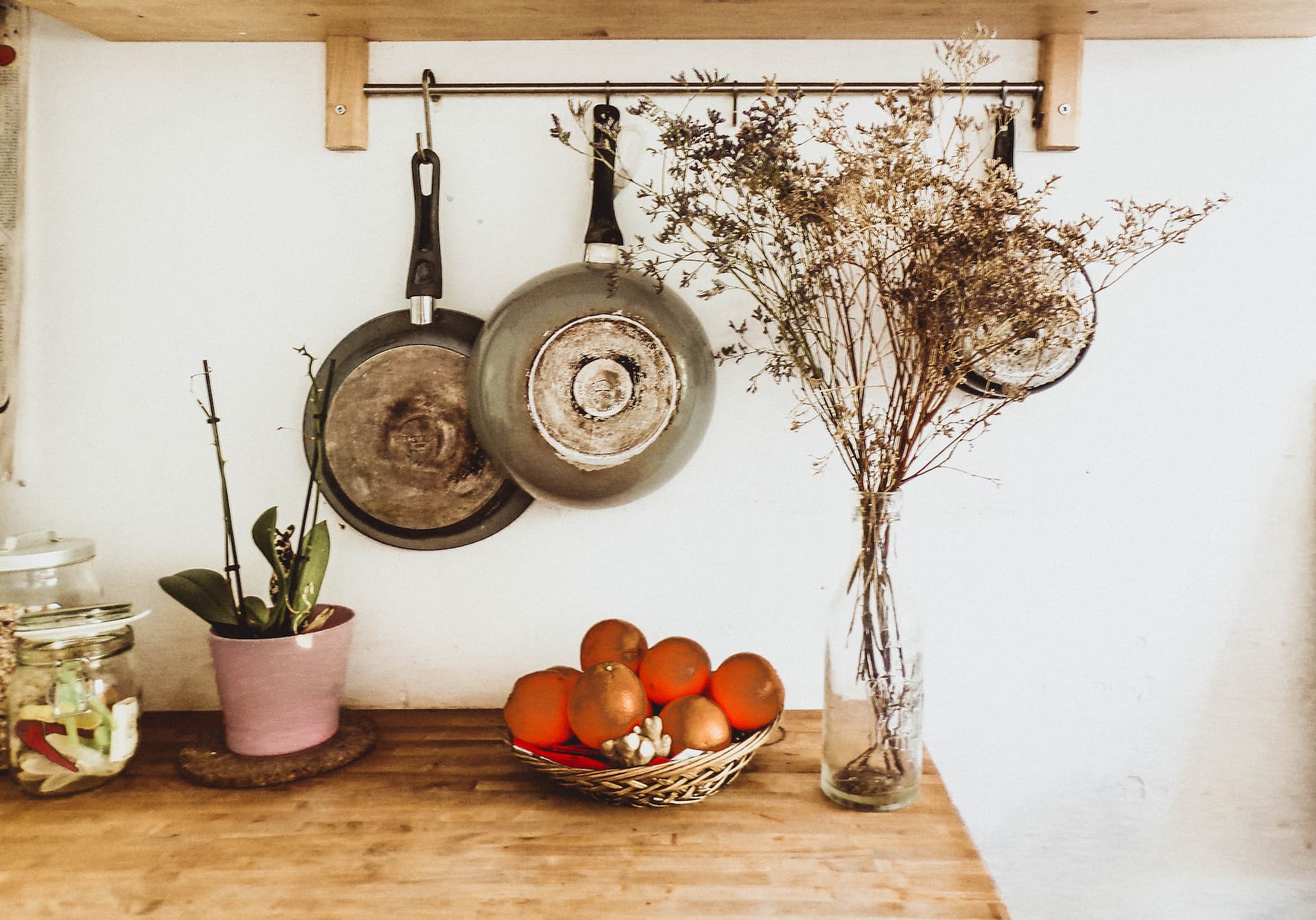 Cocina pequeña con barra para colgar sartenes.